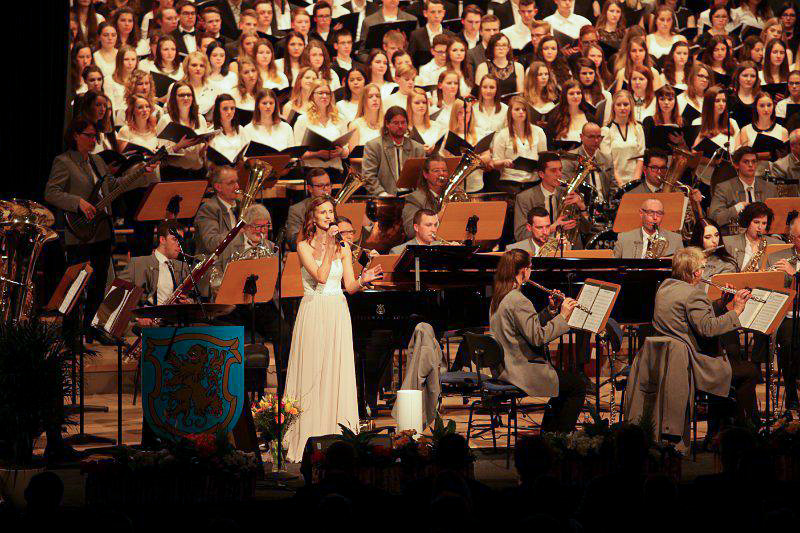 Sabrina Rammler singt auf einer großen Bühne mit Chor und Orchester